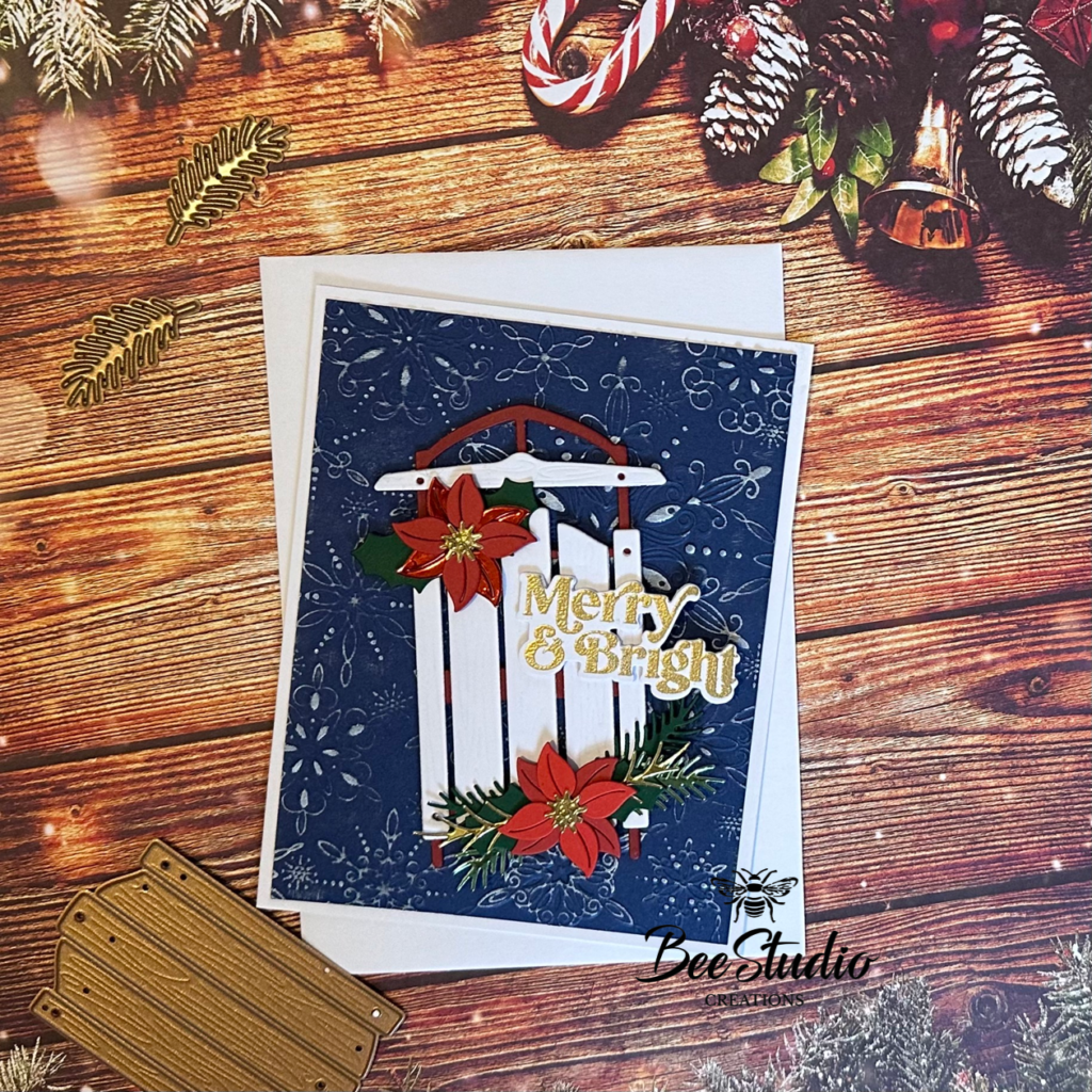 Completed cards with dark blue & white backgrounds, sledge, ice skates and poinsettia. 